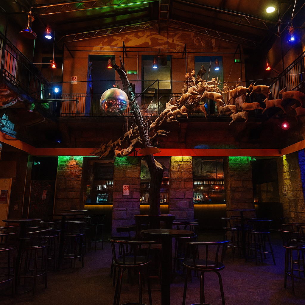 Interno di una ruin bar a Budapest con muri in mattoni a vista, toni scuri e luci colorate che illuminano tavoli vuoti e decorazioni artistiche.